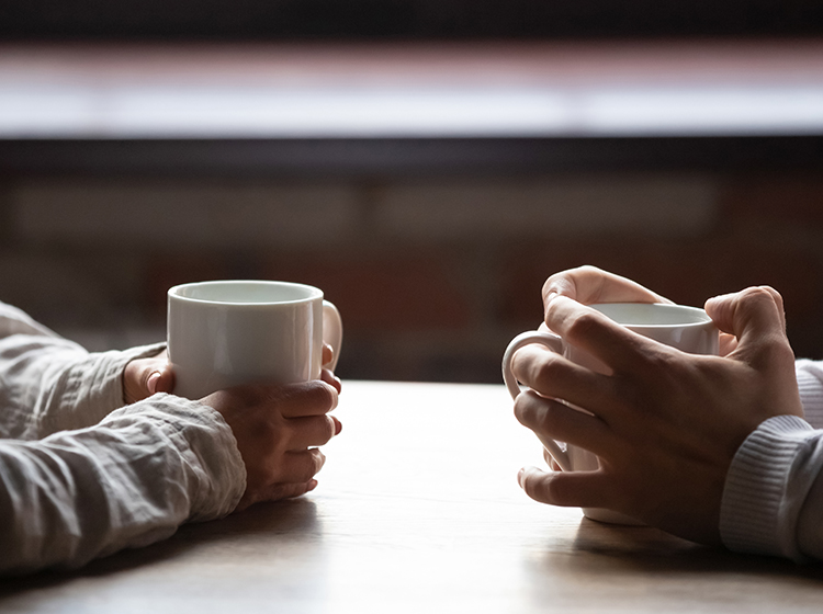 couple in café holding coffee cups