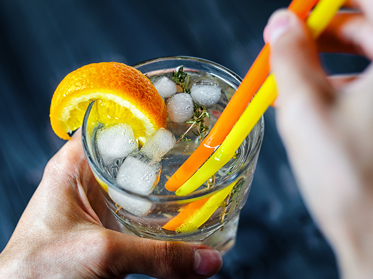 Gin mixed with tonic, and a slice of orange and rosemary