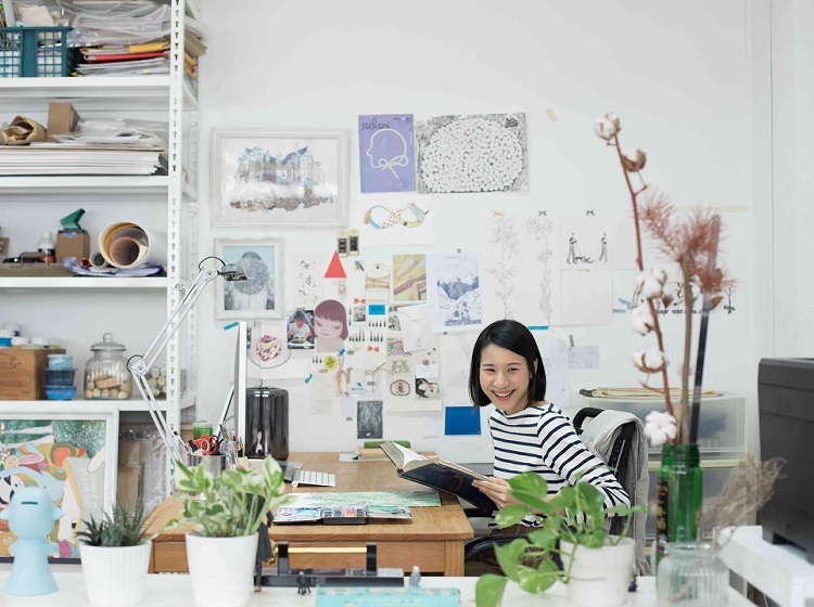 tan xi zi at her studio surrounded by plants and art
