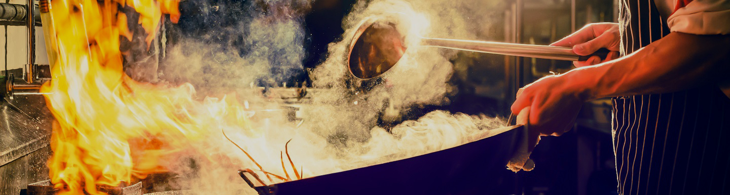  chef stirring food in a wok 