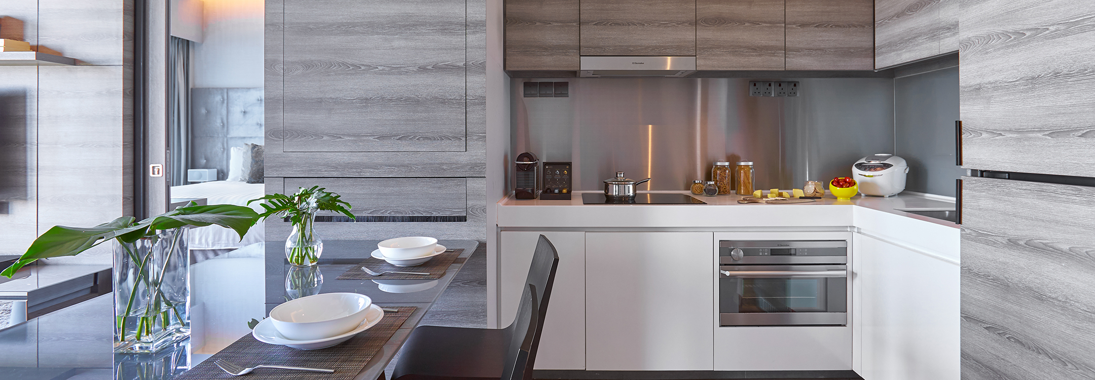A fully functional kitchen with a dining table at Pan Pacific Serviced Suites Beach Road