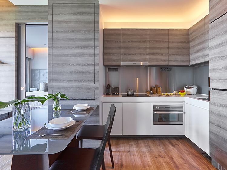 A fully functional kitchen with a dining table at Pan Pacific Serviced Suites Beach Road